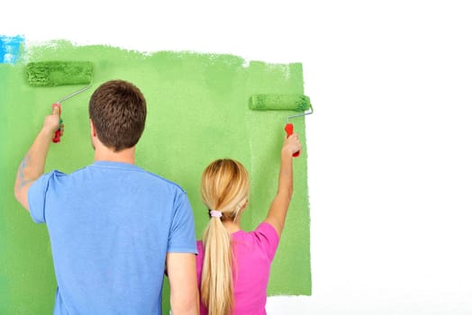 happy young couple paint in green and blue color white wall of their new home