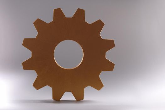 Golden detail of gear wheel of mechanism lying on gray background closeup. Repair of mechanical products concept