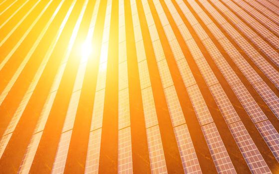 Aerial top view of a solar panels power plant. Photovoltaic solar panels at sunrise and sunset in countryside from above. Modern technology, climate care, earth saving, renewable energy concept