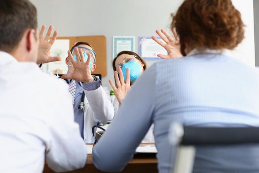 Portrait of medical workers protect from patients wearing face mask and glasses. Man and woman doctors consult clients in office. Healthcare, help concept