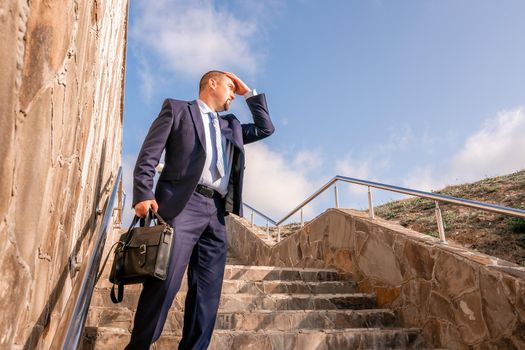 Business executive with briefcase going down the stairs.