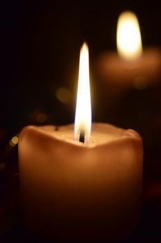 Burning beige candles as a close-up