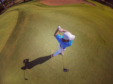 top view of golf player hitting shot with club on course at beautiful morning