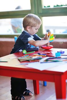 happy little child play game and have fun, education lessons in colorful kinder garden playground indoors