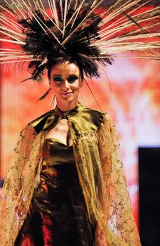 fashion show catwalk with beautiful young  woman in elegant and luxury dress with bird  peacock feather decoration