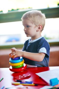 happy little child play game and have fun, education lessons in colorful kinder garden playground indoors