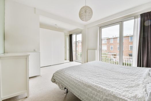 Large sleeping area with a round designer chandelier above the soft bed