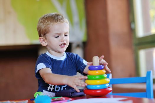 happy little child play game and have fun, education lessons in colorful kinder garden playground indoors