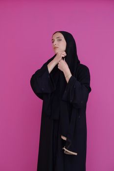 Modern young muslim woman in black abaya. Arab girl wearing traditional clothes and posing in front of black chalkboard. Representing modern and rich arabic lifestyle