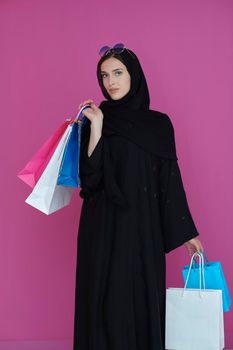 Happy muslim girl posing with shopping bags. Arabic woman wearing traditional black clothes and sunglasses representing rich and  luxurious lifestyle