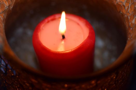 Burning red candle as a close-up