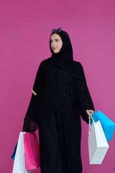 Happy muslim girl posing with shopping bags. Arabic woman wearing traditional black clothes and sunglasses representing rich and  luxurious lifestyle