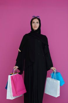 Happy muslim girl posing with shopping bags. Arabic woman wearing traditional black clothes and sunglasses representing rich and  luxurious lifestyle