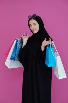 Happy muslim girl posing with shopping bags. Arabic woman wearing traditional black clothes and sunglasses representing rich and  luxurious lifestyle