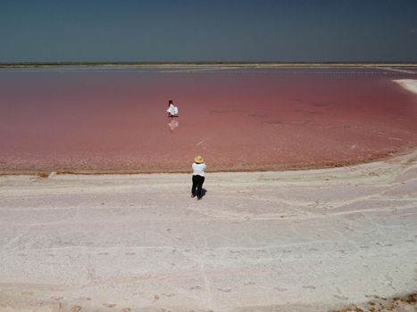 Aerial drone footage of a pink salt lake on a beautiful summer evening. Aerial view of a dried pink salt lake on a beautiful summer evening. Aerial view of a drying out salt lake.