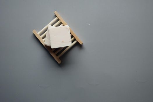 Homemade natural soap bar on black background .