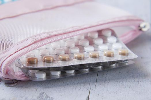 birth control pills on wooden background, close up .