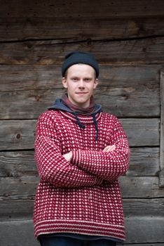 portrait of young hipster,  man with nose piercing  in front of old vintage wooden house