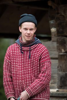 portrait of young hipster,  man with nose piercing  in front of old vintage wooden house