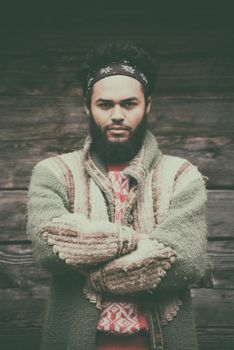 portrait of young hipster,  man with beard in front of old vintage wooden house