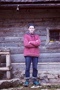 portrait of young hipster,  man with nose piercing  in front of old vintage wooden house