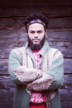 portrait of young hipster,  man with beard in front of old vintage wooden house