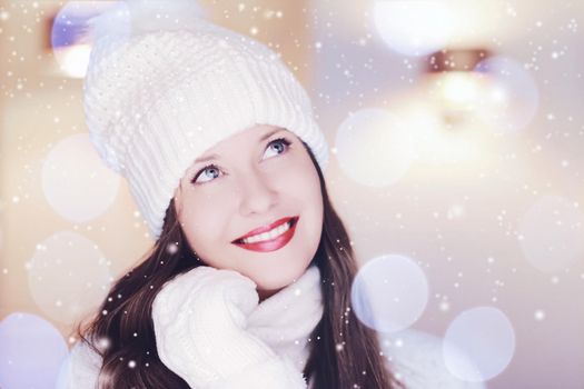 Christmas, people and winter holiday concept. Happy smiling woman wearing white knitted hat as closeup face xmas portrait, snow glitter and bokeh effect.