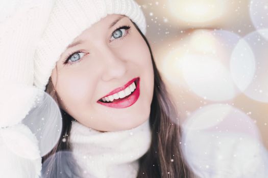Christmas, people and winter holiday concept. Happy smiling woman wearing white knitted hat as closeup face xmas portrait, snow glitter and bokeh effect.