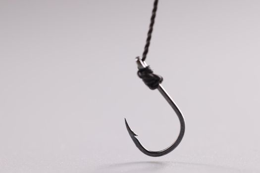 Closeup of fishing hook on string on gray background. Fraud concept