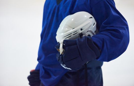 young ice hockey player portrait on training in black background