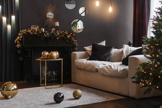 Christmas interior with a beautiful Christmas tree, sofa, light bulbs and dark background. Home New Year's interior.