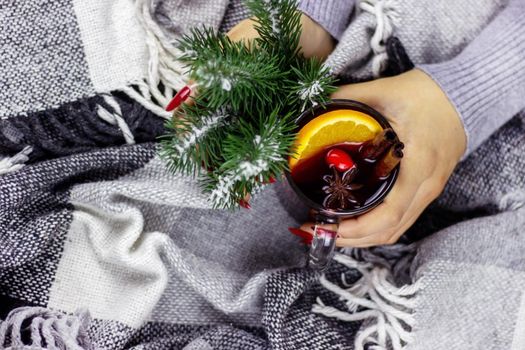 Hot mulled wine in male and female hands, spices. Sweet home concept