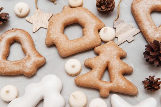 Banner for Christmas and New Year gingerbread stars, houses, Christmas trees, toys on a gray concrete background, Christmas lights bokeh in the foreground.