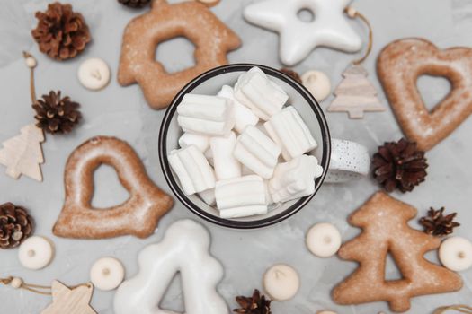 A cup of cocoa with marshmallows and New Year's gingerbread and a gift on the table. The concept of desserts and drinks during the Christmas holidays.