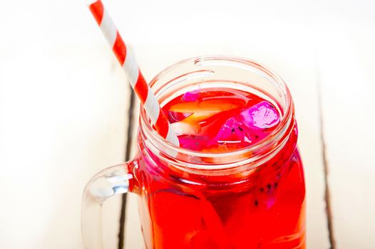 fresh fruit punch refreshing summer  drink over white rustic wood table