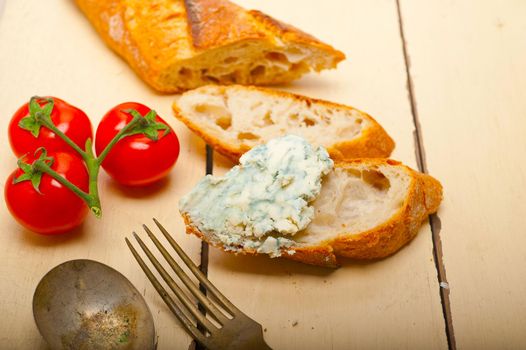 fresh blue cheese spread ove french baguette with cherry tomatoes on side