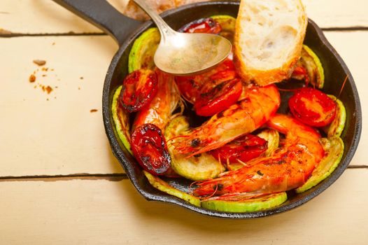 roasted shrimps on cast iron skillet  with zucchini and tomatoes