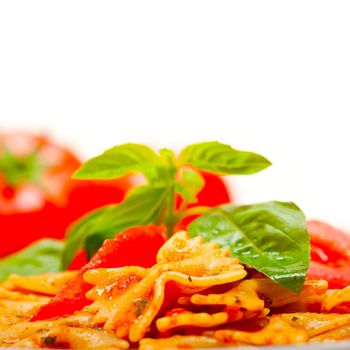 Italian pasta farfalle butterfly bow-tie with tomato basil sauce over white rustic wood table