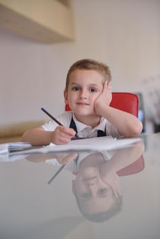 young mom woman doing home work with elementary school grade boy at home in kitchen