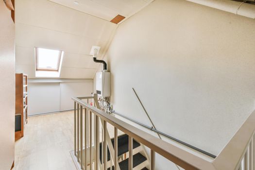 Attic room with a staircase and shelving and a small window