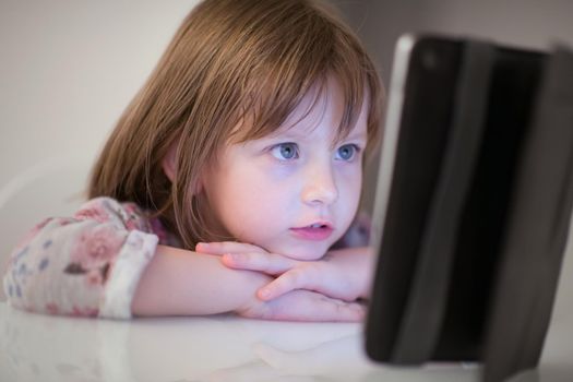 child playing with digital tablet at home