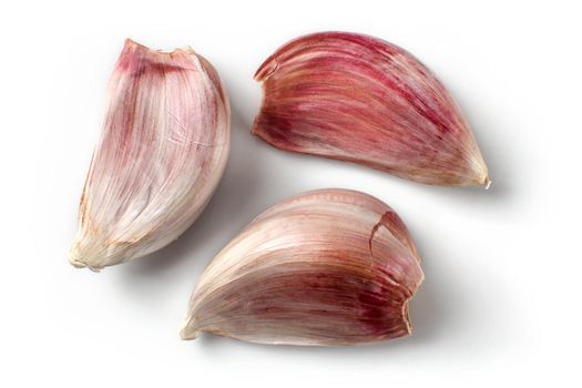 Top view on three purple garlic cloves isolated (with shadows) on white background.