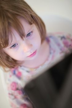 child playing with digital tablet at home