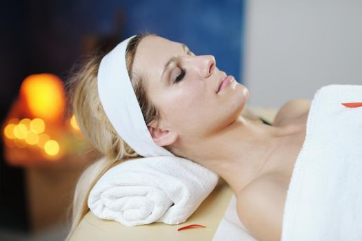 Beautiful young woman in spaand wellness. Face back and  stone massage