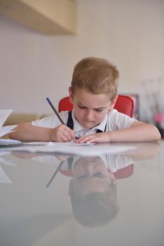 young mom woman doing home work with elementary school grade boy at home in kitchen