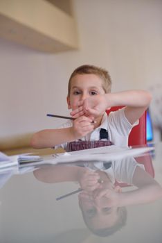 young mom woman doing home work with elementary school grade boy at home in kitchen