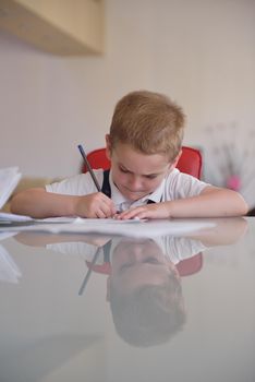 young mom woman doing home work with elementary school grade boy at home in kitchen