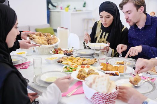 Eid Mubarak Muslim family having Iftar dinner  Eating traditional food during Ramadan feasting month at home. The Islamic Halal Eating and Drinking Islamic family