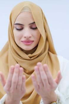 beautiful muslim woman in fashionable dress with hijab making traditional prayer to God, keeps hands in praying gesture isolated on white background representing modern islam fashion and ramadan kareem concept