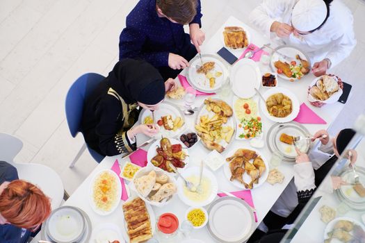 Eid Mubarak Muslim family having Iftar dinner  Eating traditional food during Ramadan feasting month at home. The Islamic Halal Eating and Drinking Islamic family top view